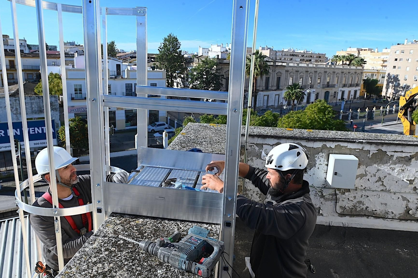 Dos operarios montando una de las placas fotovoltaicas en la estación de autobuses de Jerez