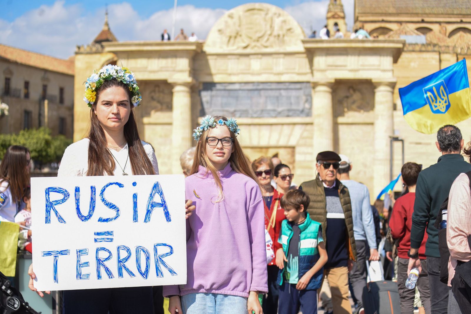 Tetiana Bataieva, junto a su hija en el Puente Romano, sostiene una pancarta contra Rusia.