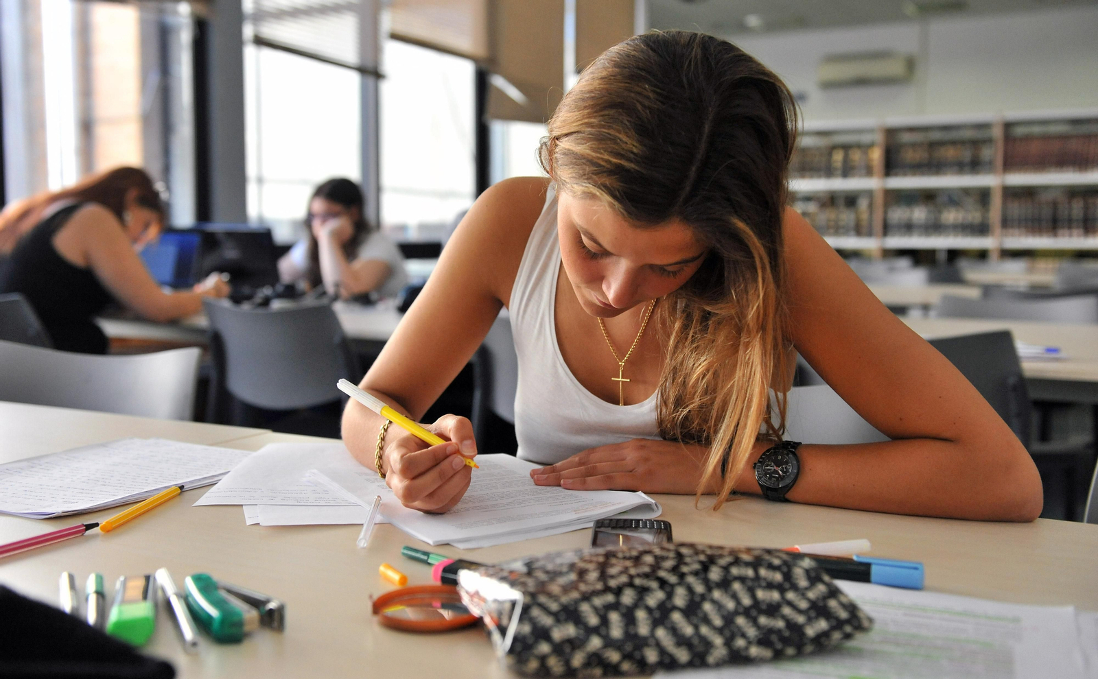 Una alumna de la US estudia en una biblioteca universitaria.