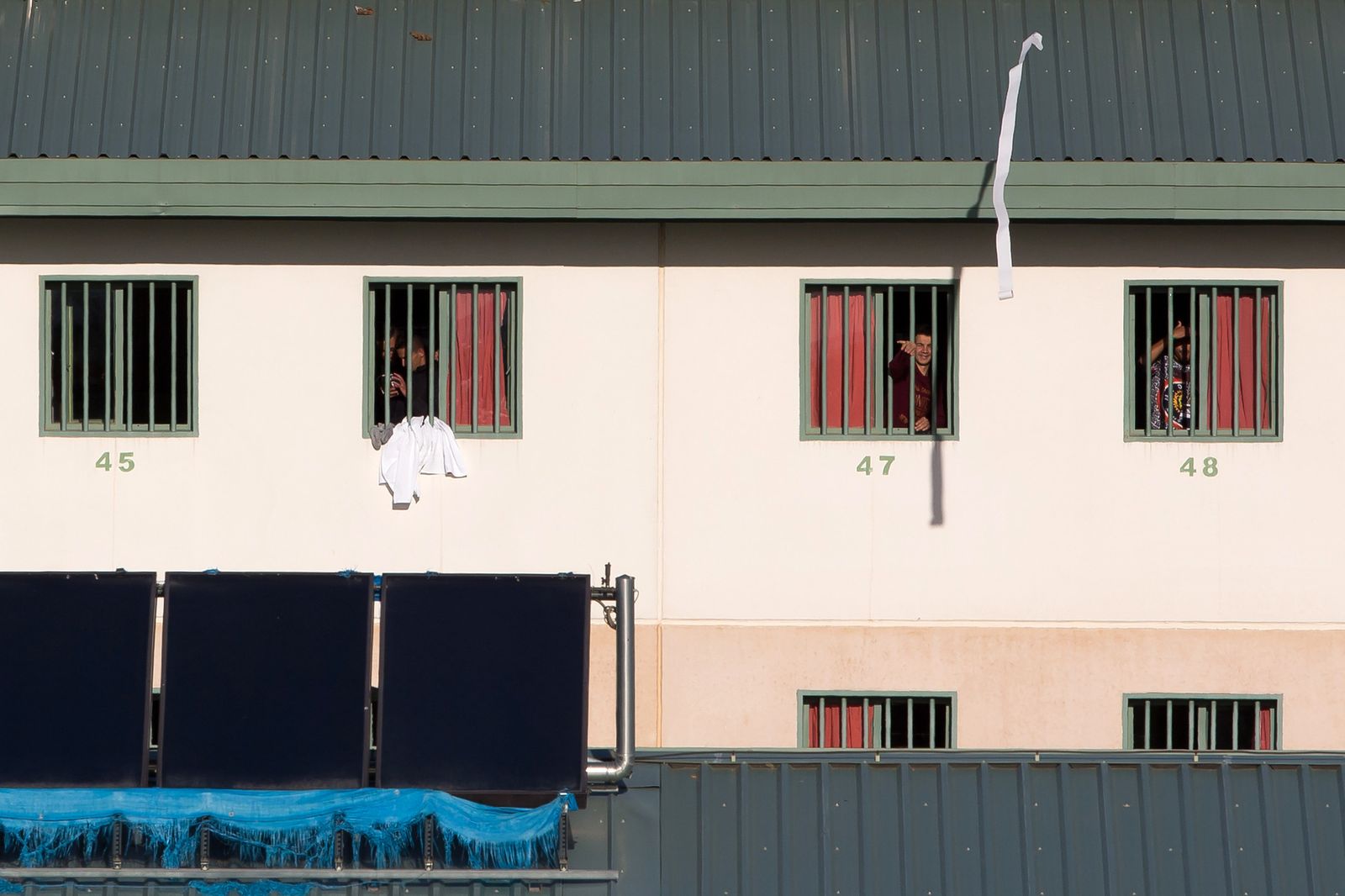 Un grupo de inmigrantes se asoma a las ventanas de la prisión de Archidona.