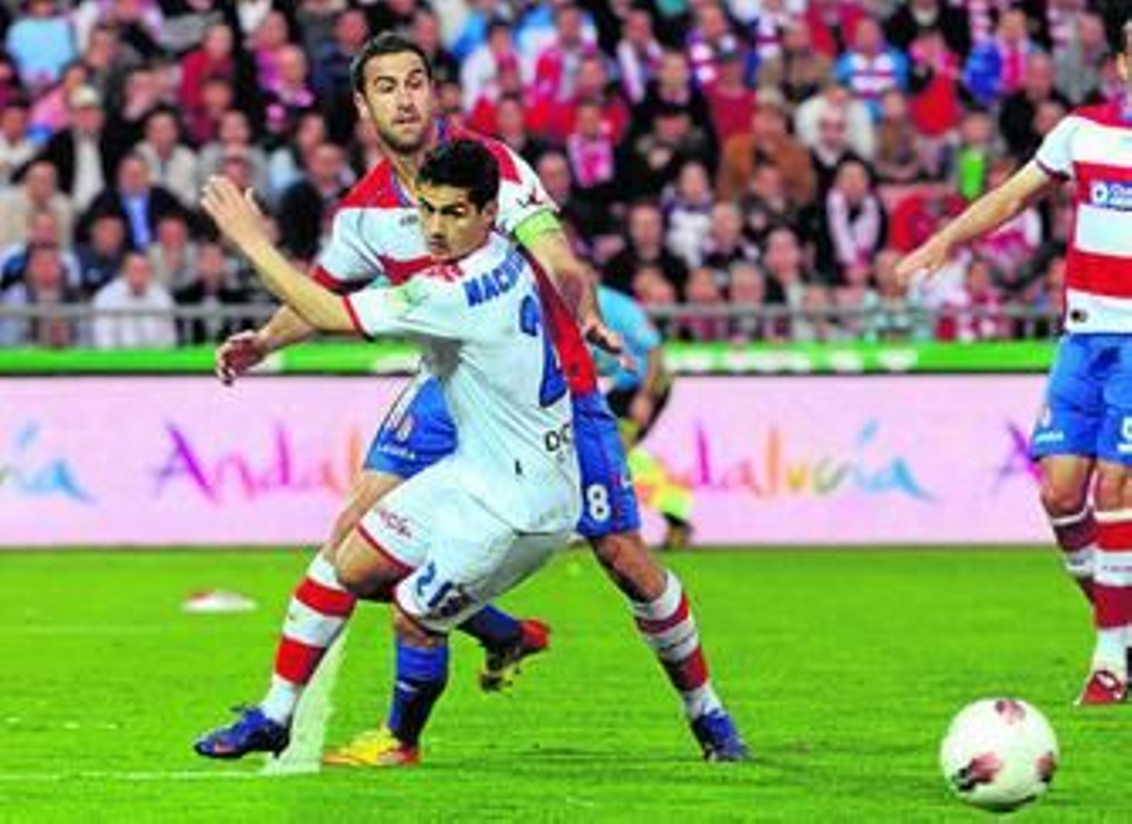 Nacho Cases se gira para evadirse de Íñigo López e ir a por el balón.