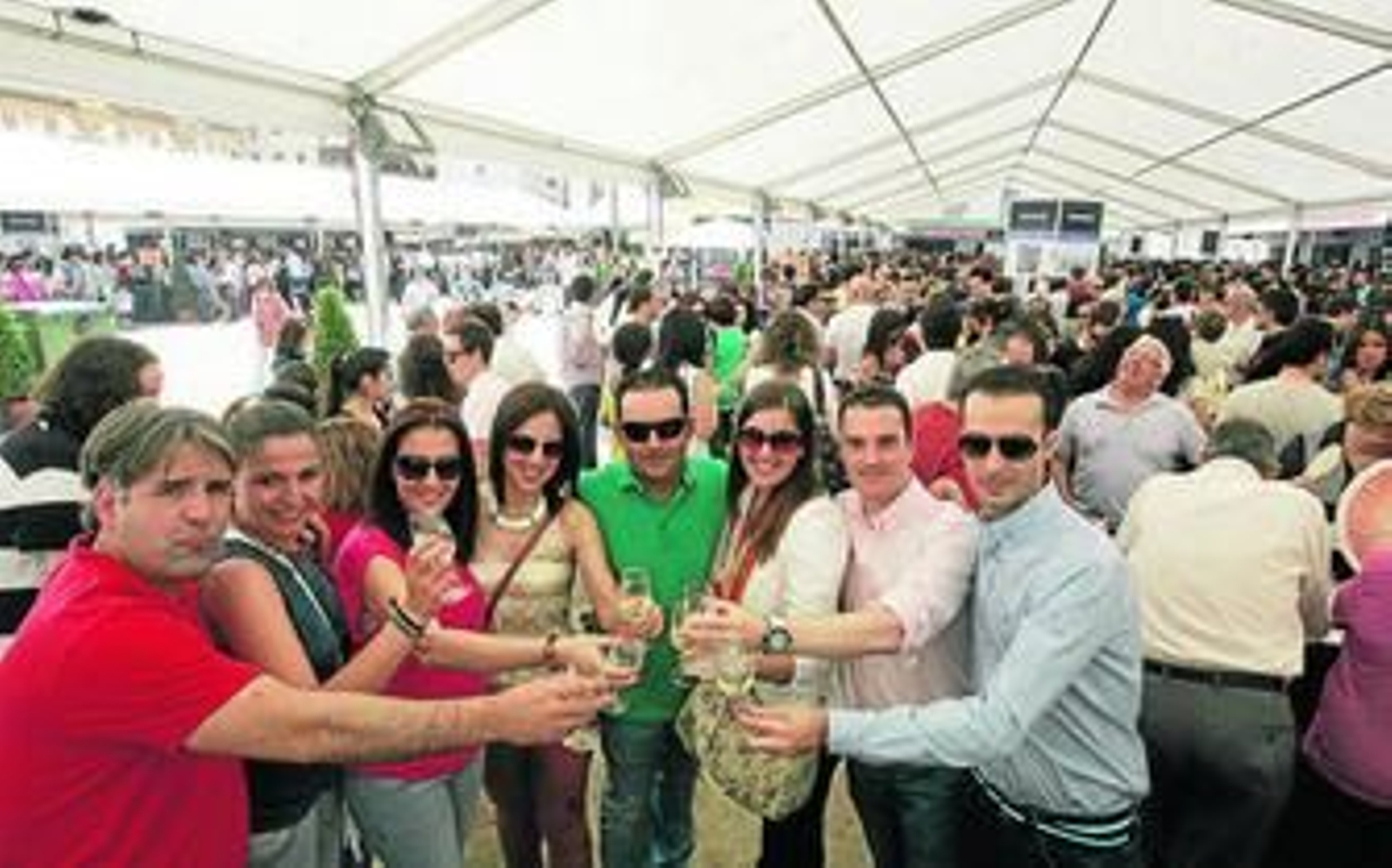 Un grupo brinda bajo una de las carpas instaladas, llena de público.