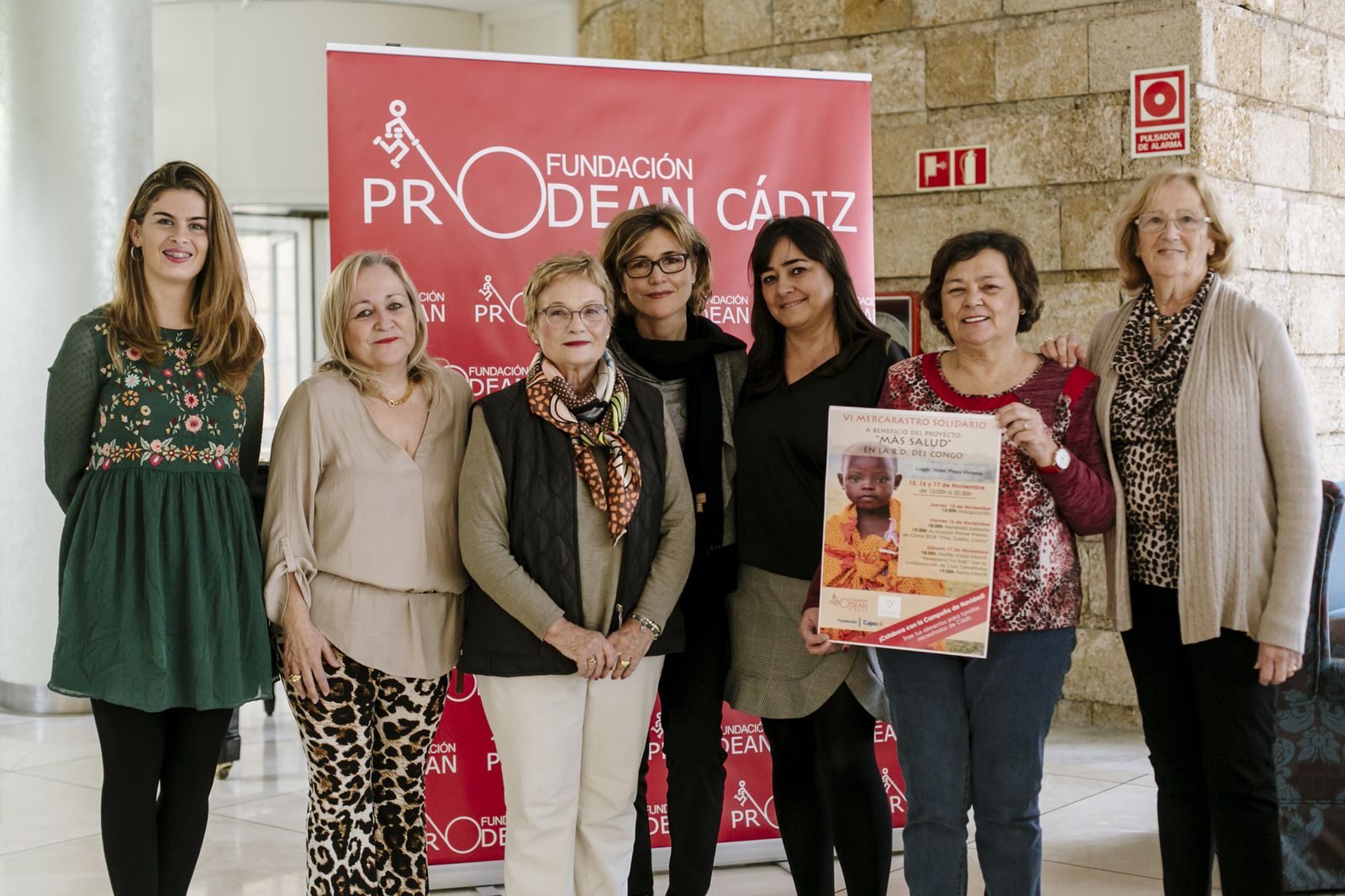 Voluntarias de Prodean con el cartel del Merca Rastro, acompañadas de la directora y la delegada comercial del Hotel Playa.