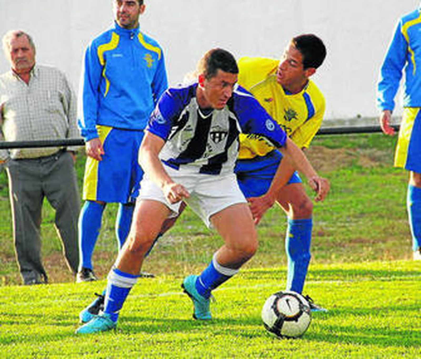 El jugador del Español de Vejer Adriano controla el balón.