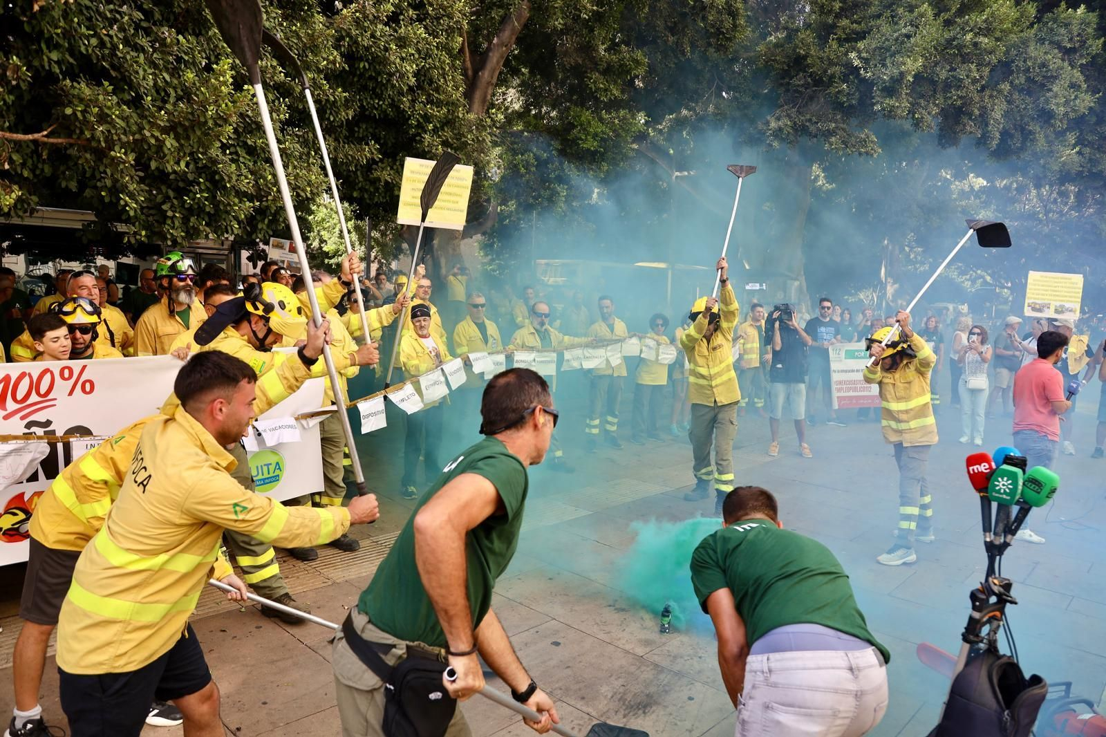 Bomberos del Infoca recrean como pagan un fuego durante la manifestación en Málaga