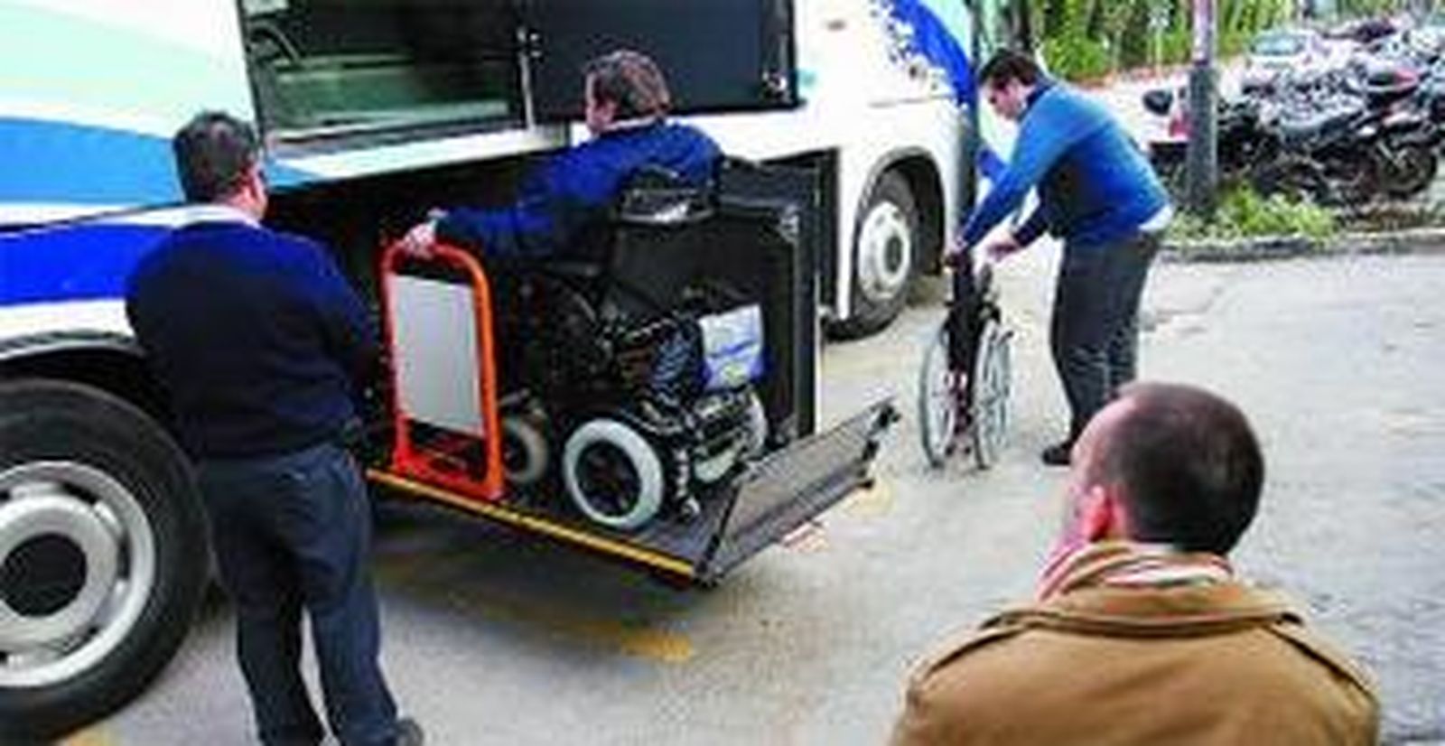 Dos discapacitados suben a un autobús adaptado.