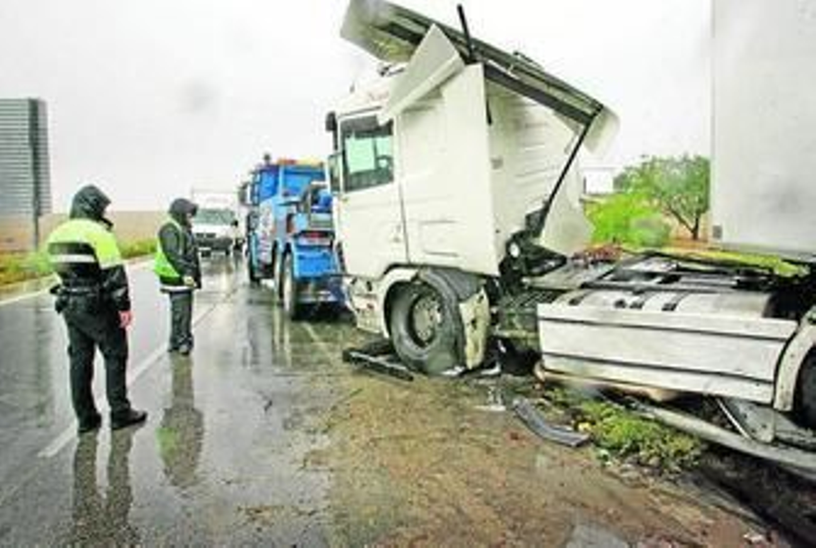 Un policía local observa cómo una grúa iza un camión siniestrado el pasado septiembre. Un policía local observa cómo una grúa iza un camión siniestrado el pasado septiembre.