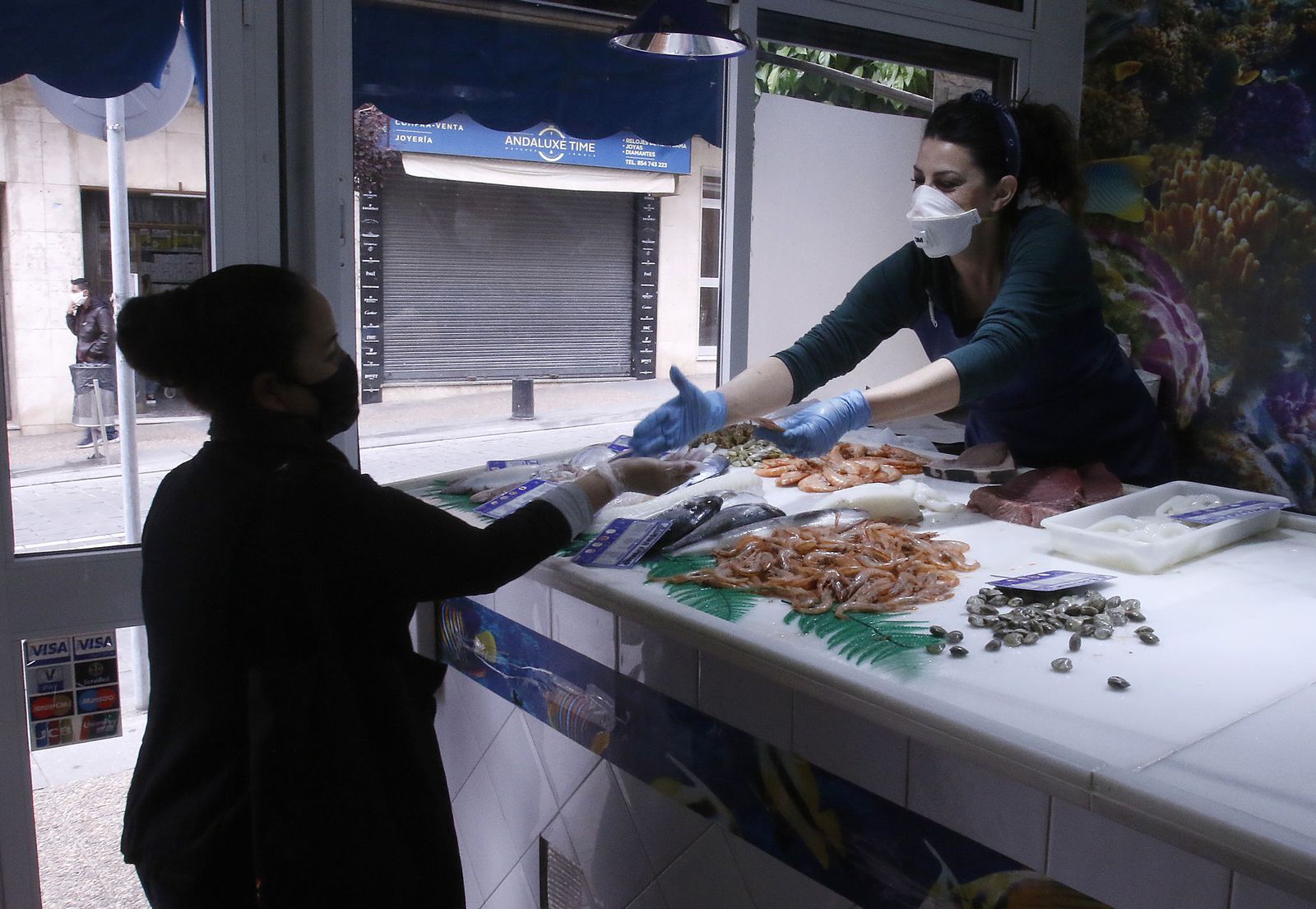 La trabajadora de una pescadería atiende a una clienta en San Juan, uno de los municipios en los que el paro aumentó entre junio y julio de 2020.