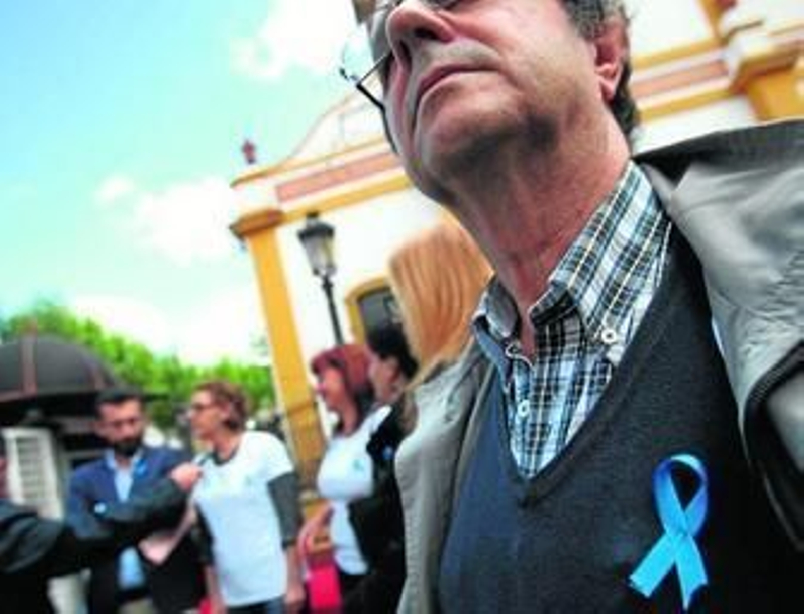 Un hombre porta un lazo azul durante la celebración del Día Mundial de la Fibromialgia en La Línea, el 12 de mayo.