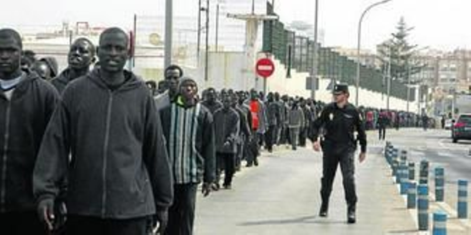 Decenas de inmigrantes subsaharianos, ayer, camino del Centro de Estancia Temporal de Melilla tras pasar por la Jefatura de Policía para ser reseñados para su expediente de expulsión.