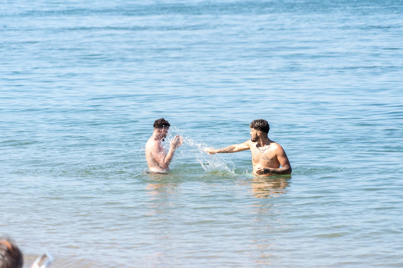 Dos bañistas disfrutan del alivio del calor en la ría de Punta Umbría.