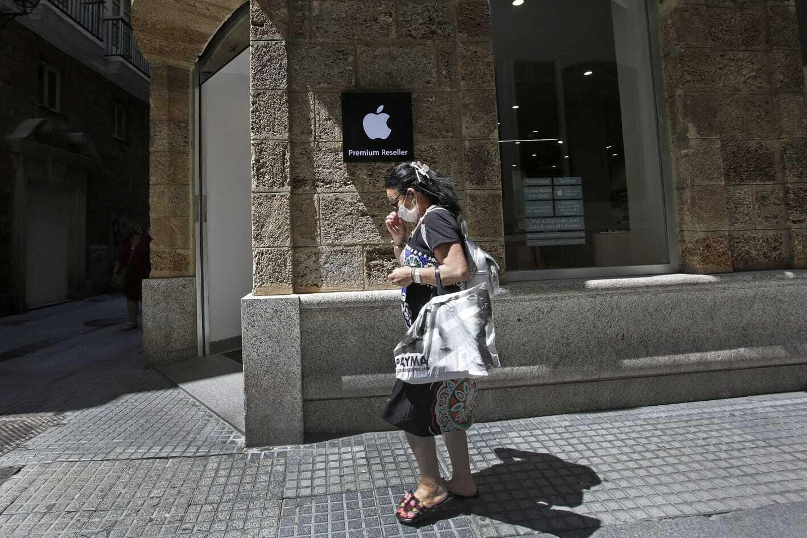 Una mujer pasa con su mascarilla por Cádiz.