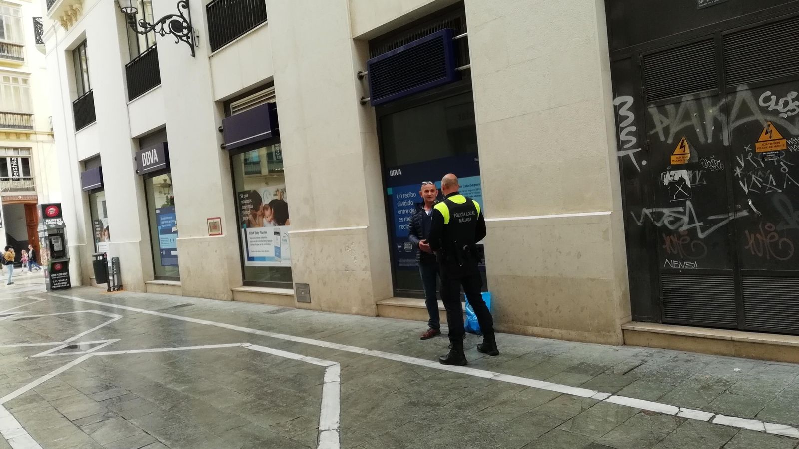 Un agente de Policía con el detenido.