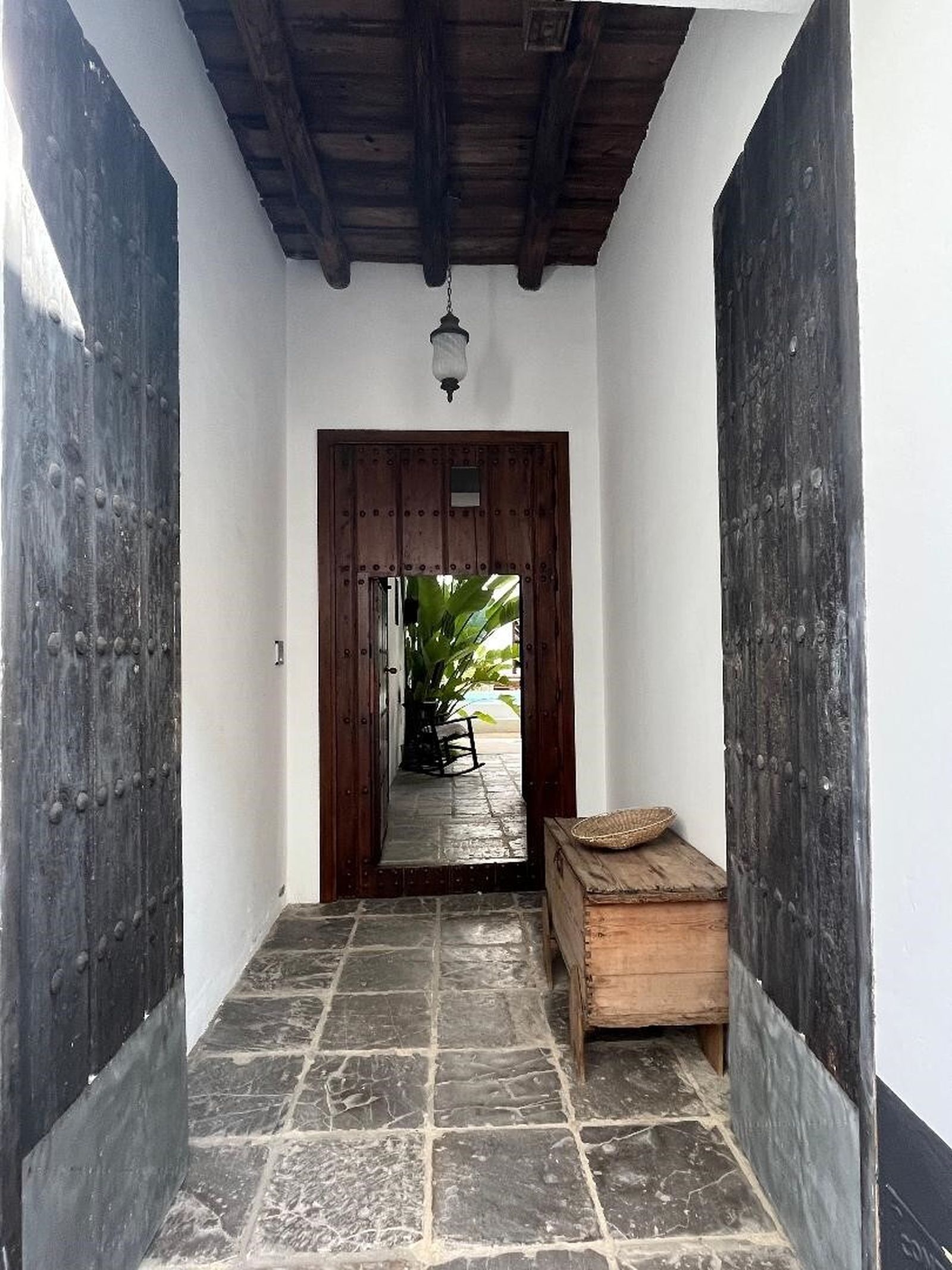 Zaguán. Suelo de piedra de Tarifa y techo original de madera junto a puertas  de clavos.