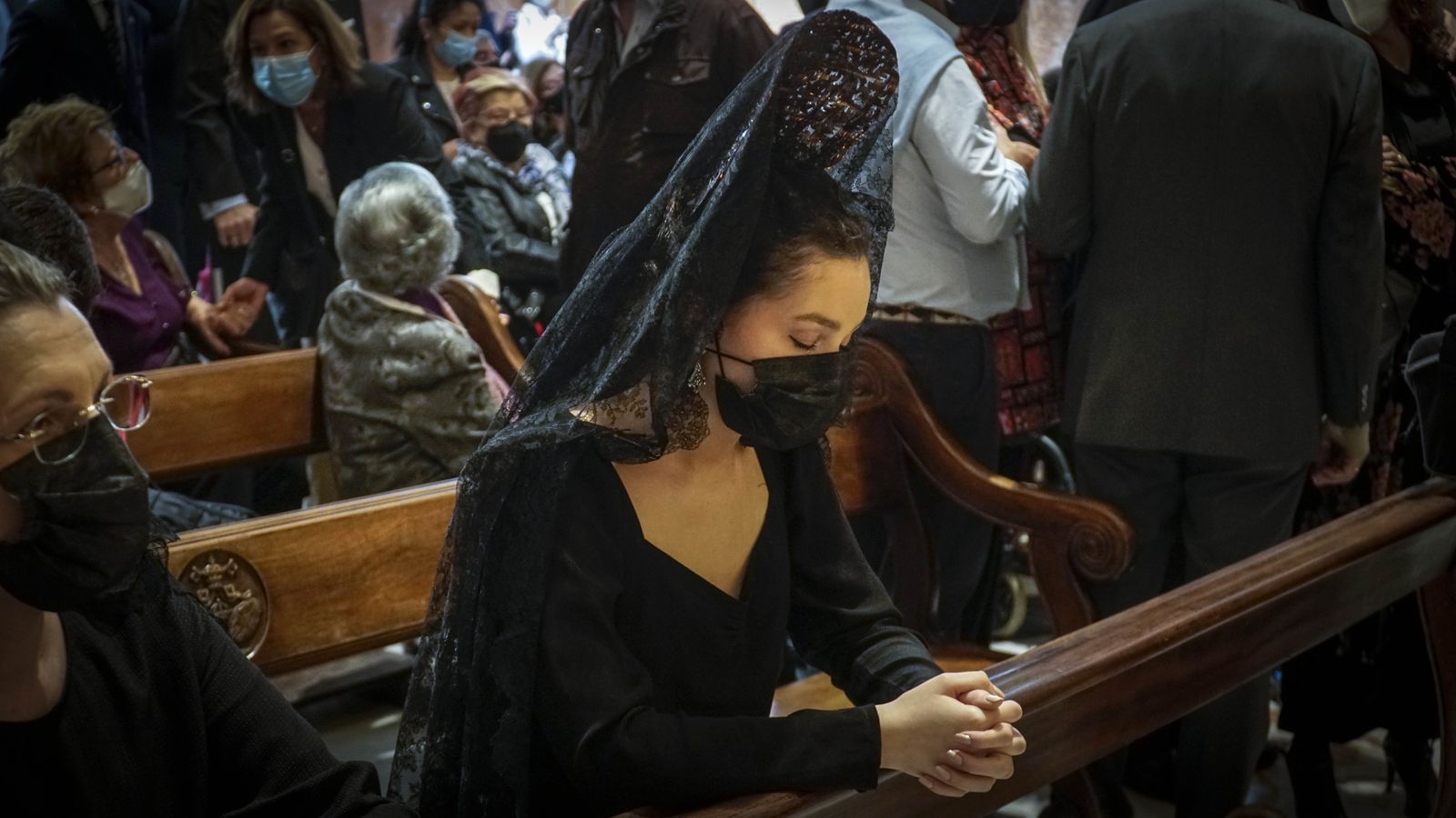 Una mujer de mantilla ora en la Basílica del Gran Poder