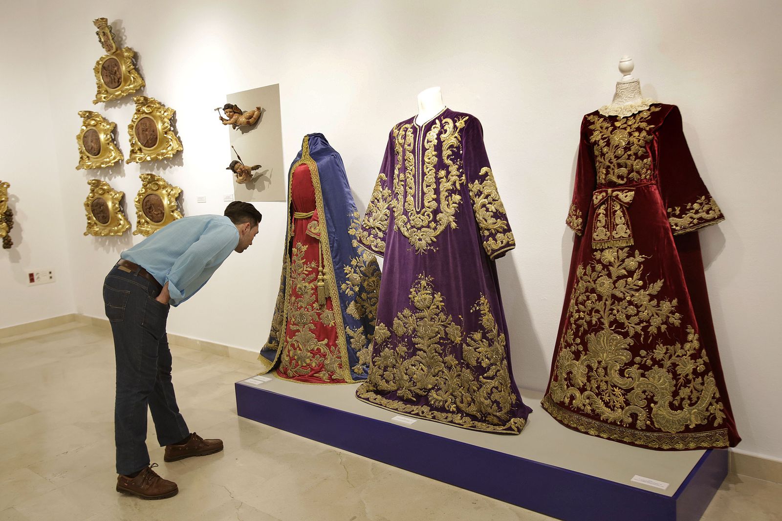 Un visitante observa algunos de los bordados de la exposición de Afligidos en Cajasol