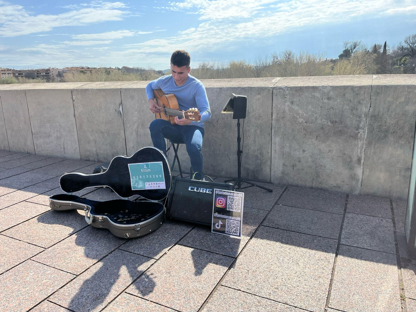 El músico Juan Antonio Navarro toca su guitarra en el Puente Romano