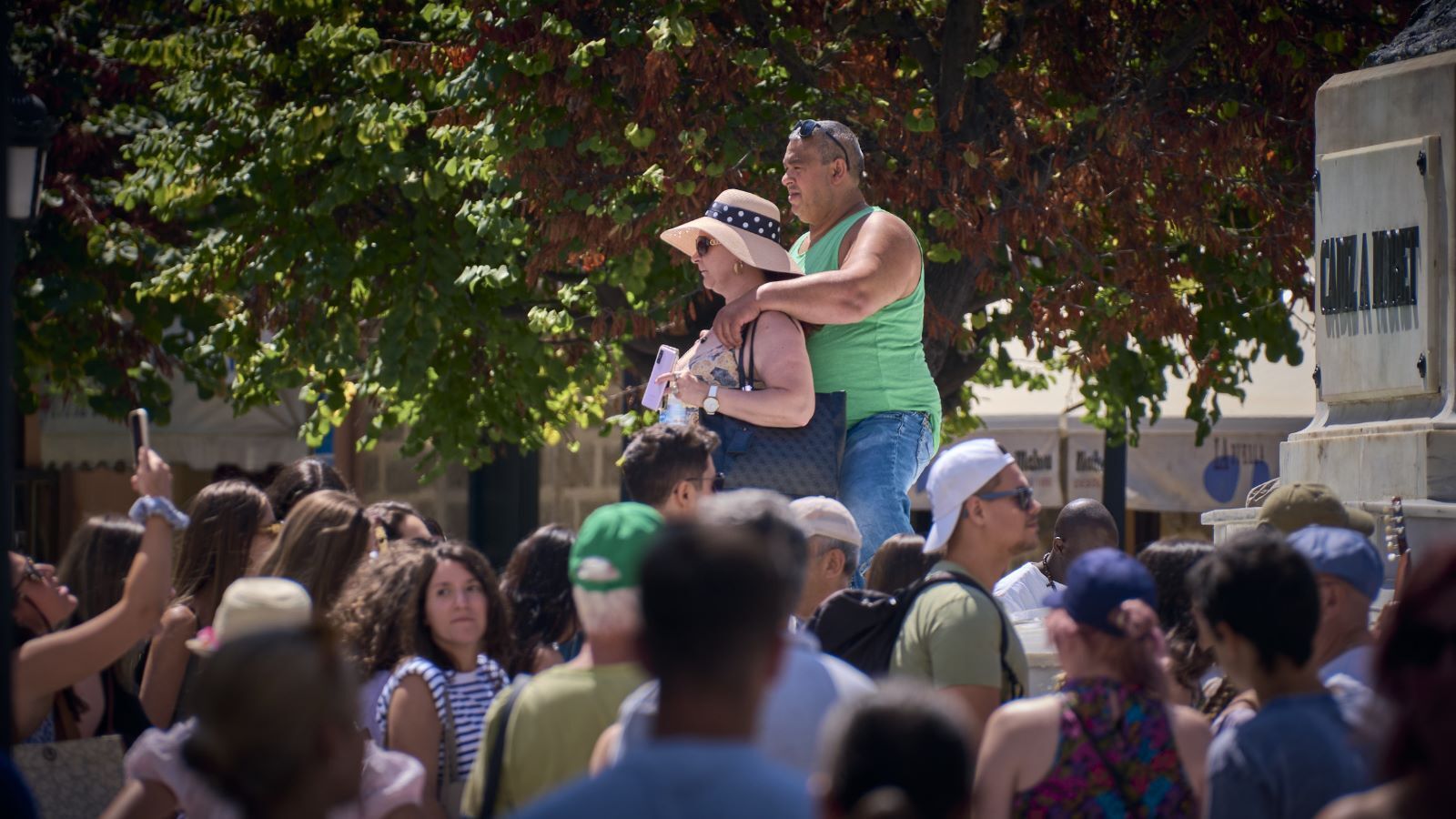Dos turistas se hacen una foto en el monumento a Moret, rodeado de muchos cruceristas más.