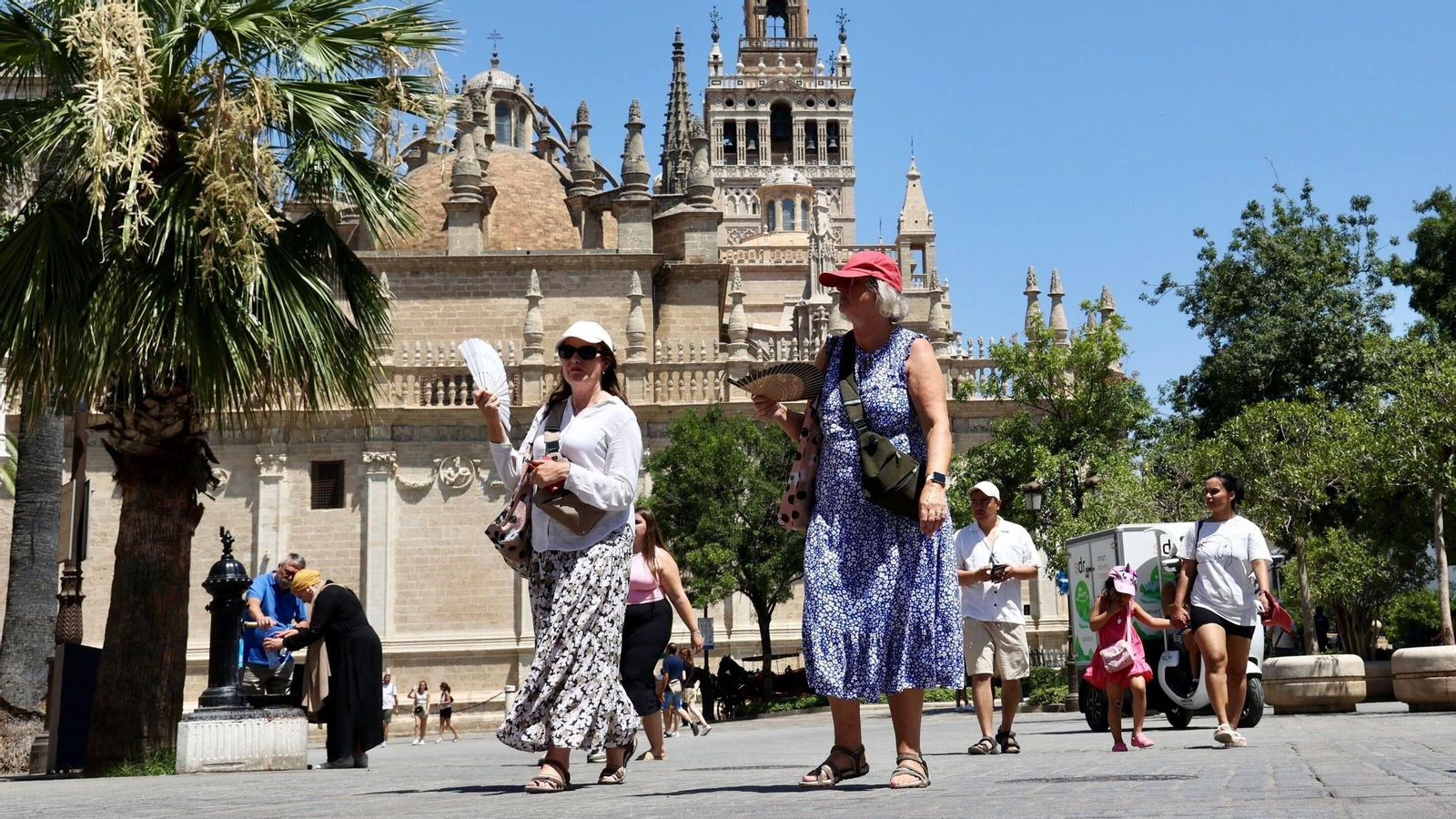 Dos turistas pasean bajo el calor de Sevilla