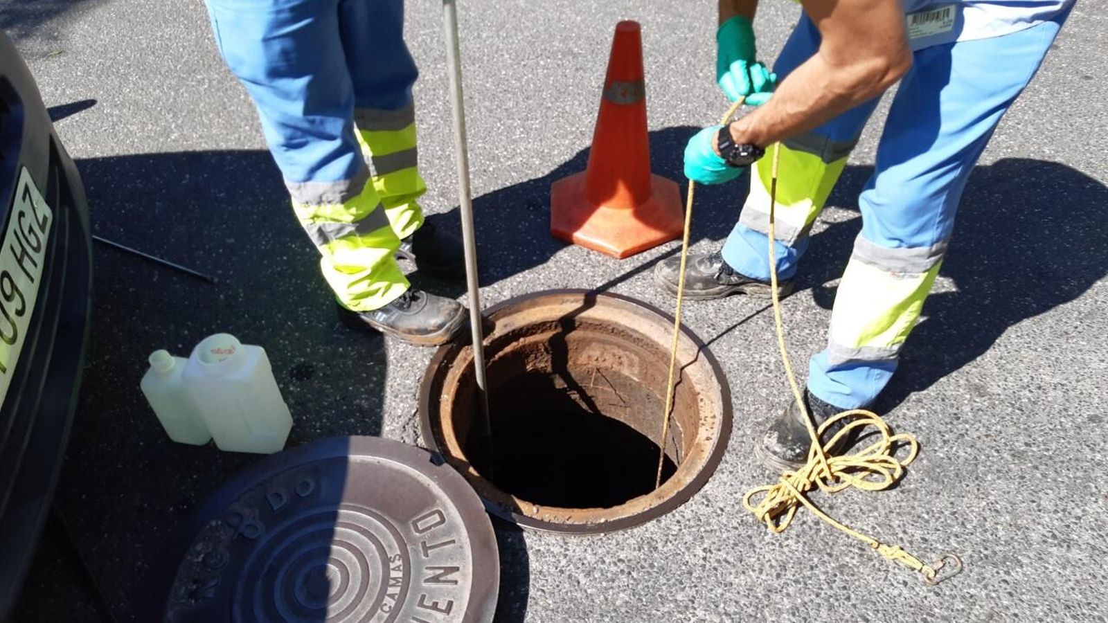 Dos empleados de Emasesa extraen muestras de la red de saneamiento.