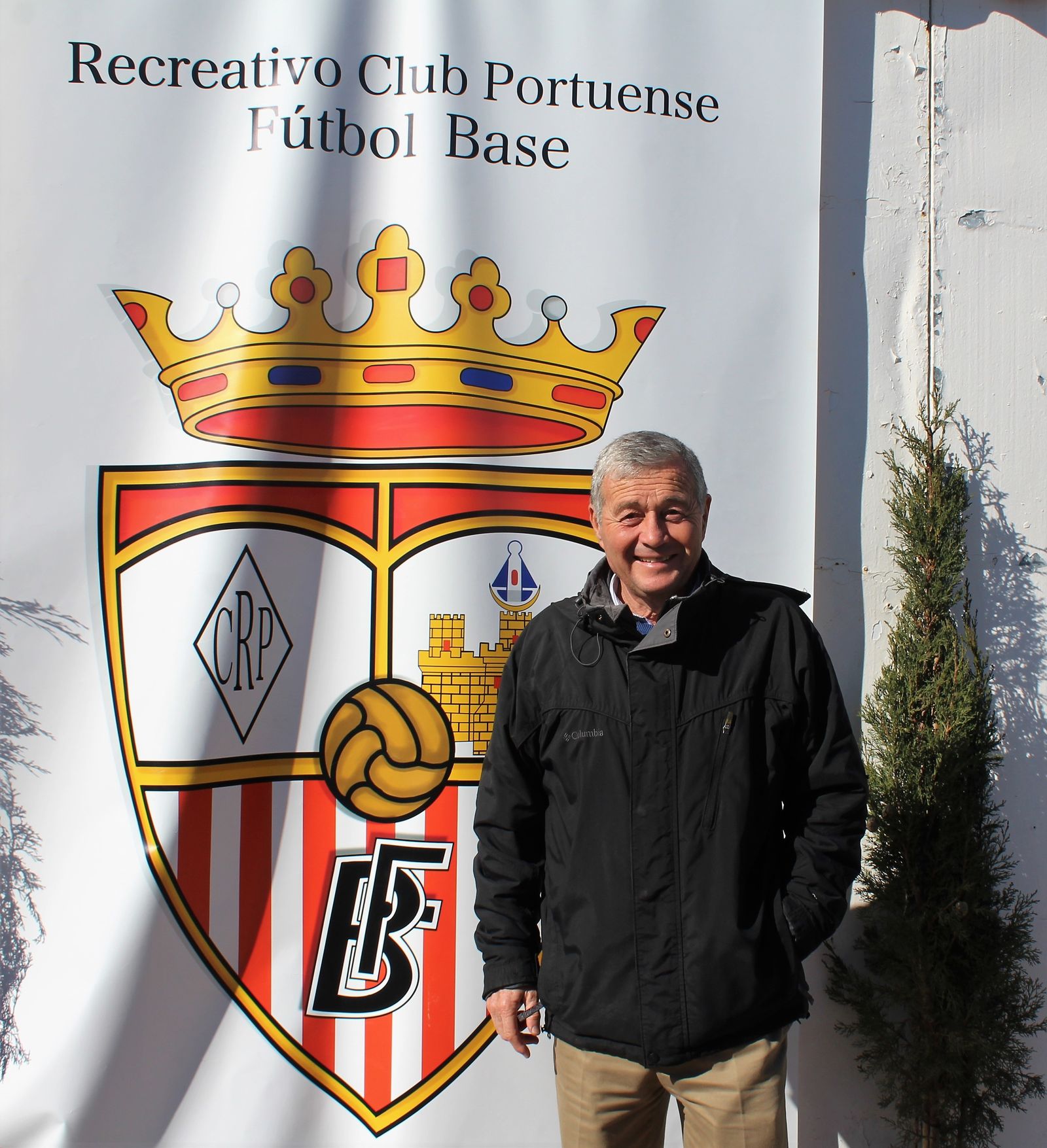 Antonio Flor, presidente del Recreativo Portuense, posa junto a un escudo del club.