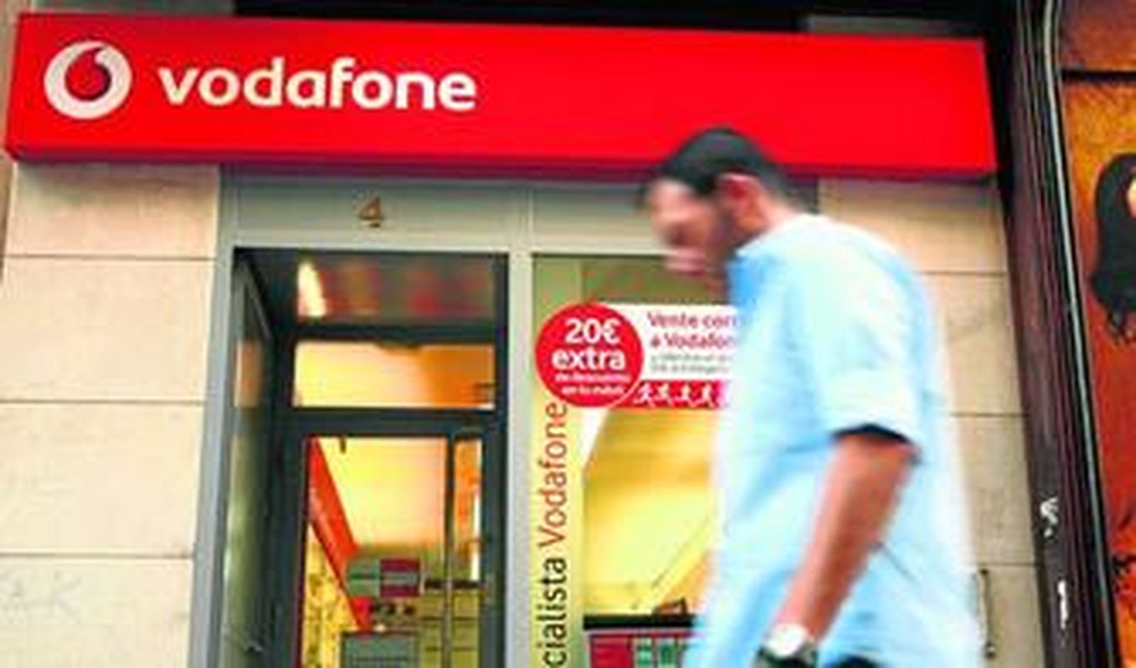 Un ciudadano pasa por delante de una tienda de Vodafone.