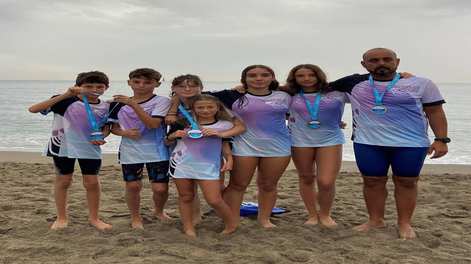 Los nadadores del  Aguadulce Swim posan con sus medallas obtenidas en la travesía de Torremolinos.