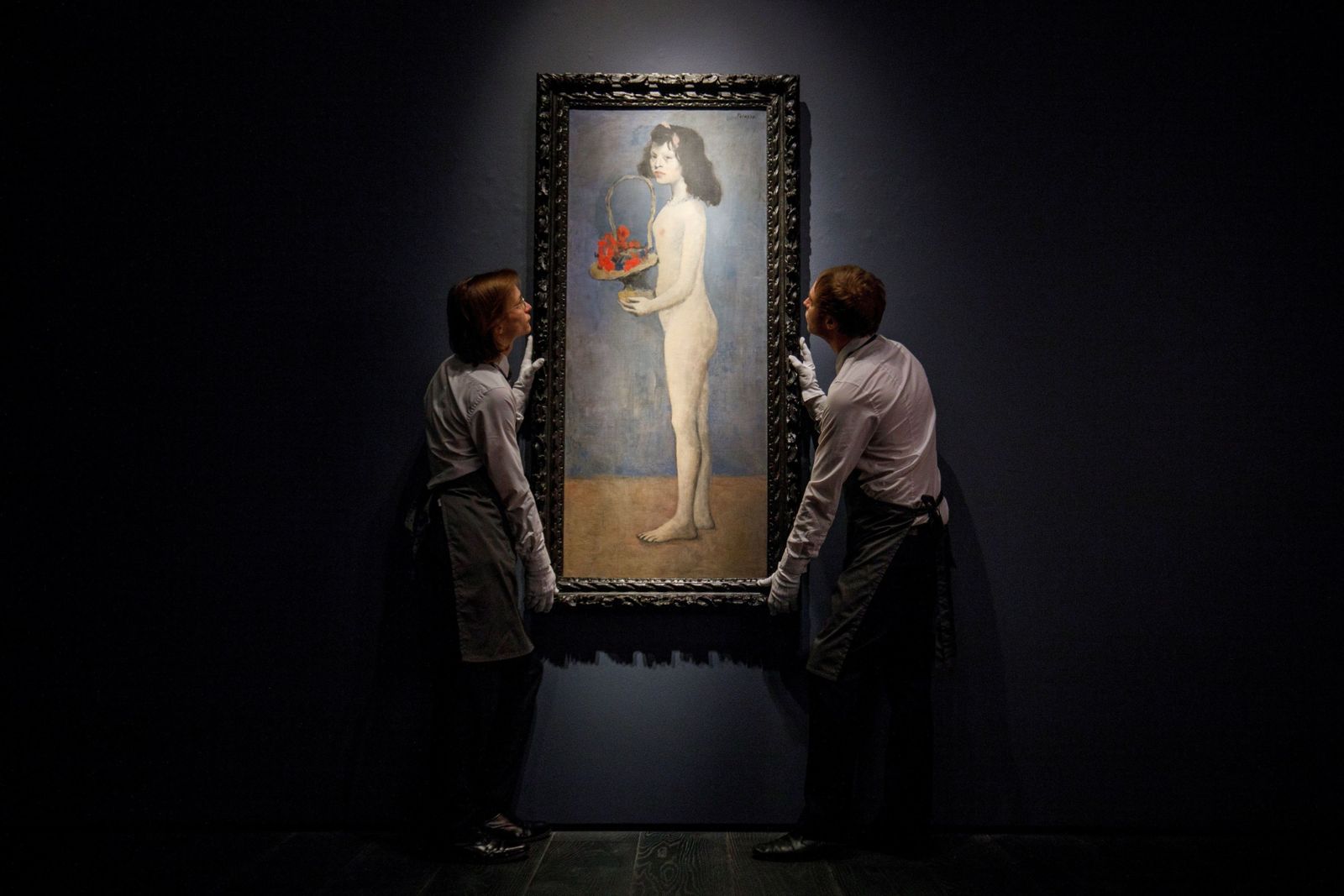 Dos trabajadores de la casa de subastas Christie’s colocan la obra.