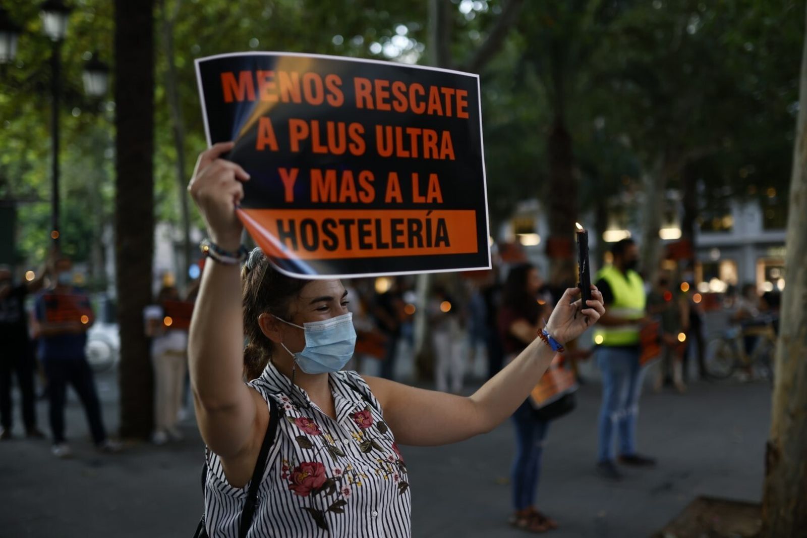 Una de las participantes en la concentración con un cartel y una vela negra.