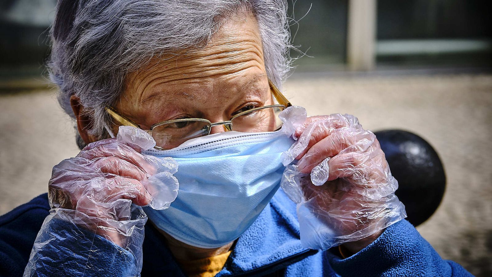 Margarita Delgado se ajusta la mascarilla con sus manos protegidas con guantes.
