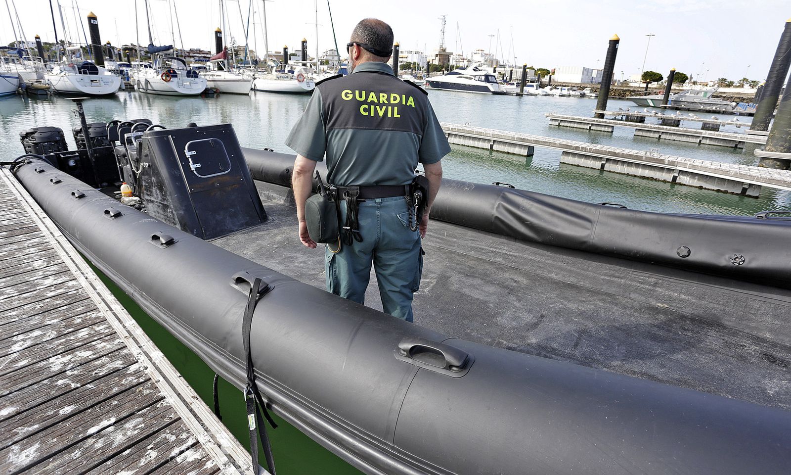 Un agente del Servicio Marítimo de la Guardia Civil en la goma intervenida, que se encontraba ayer en el puerto de Chipiona.