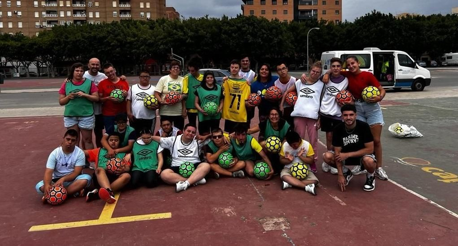 Los alumnos del Centro Educativo Down Almería posan con el jugador, abajo a la derecha, tras el entrenamiento