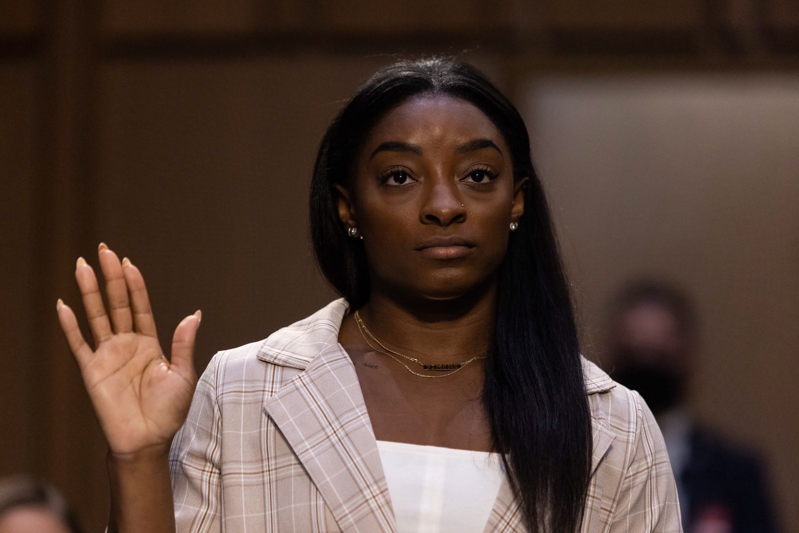 Simone Biles alza su mano para jurar por su declaración ante el Senado.