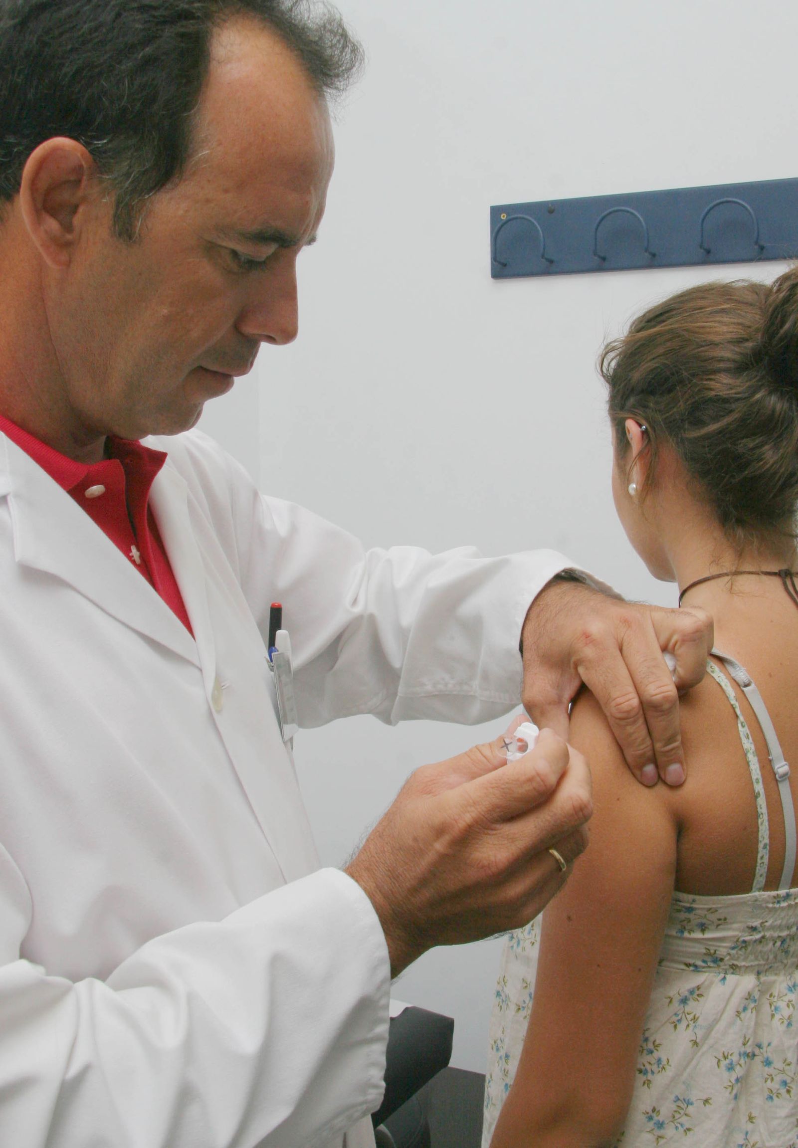 Un profesional sanitario vacuna a uno de los menores en un centro de salud.