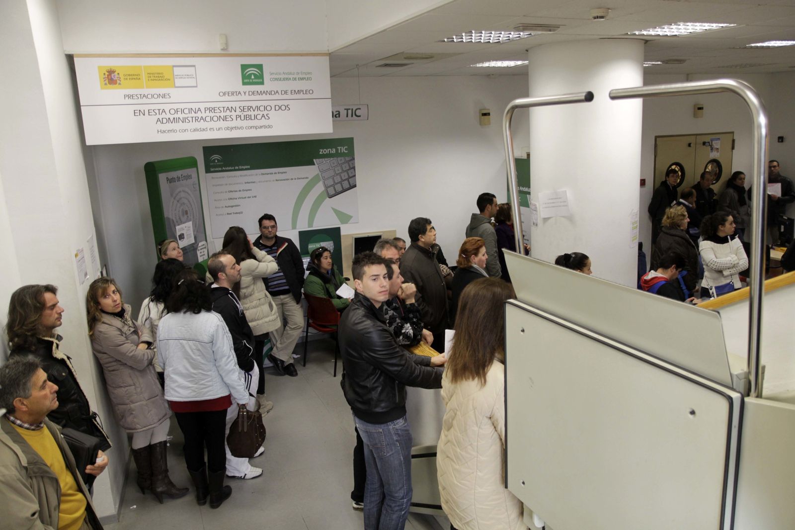 Un grupo de personas espera en una oficina de empleo.