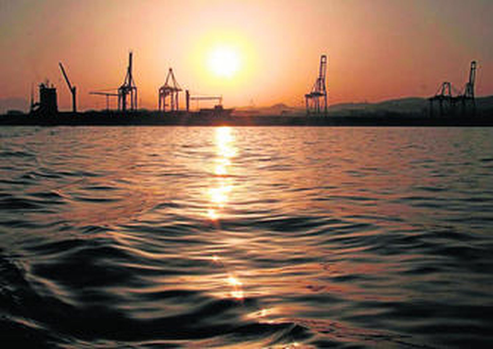 Atardecer en la bahía malagueña con la terminal de contenedores al fondo.