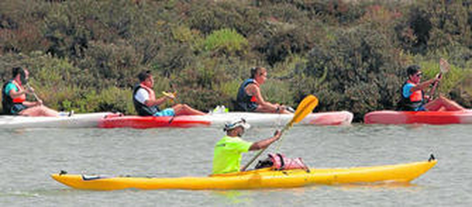 Jóvenes practican con el kayak por el caño de Sancti Petri.