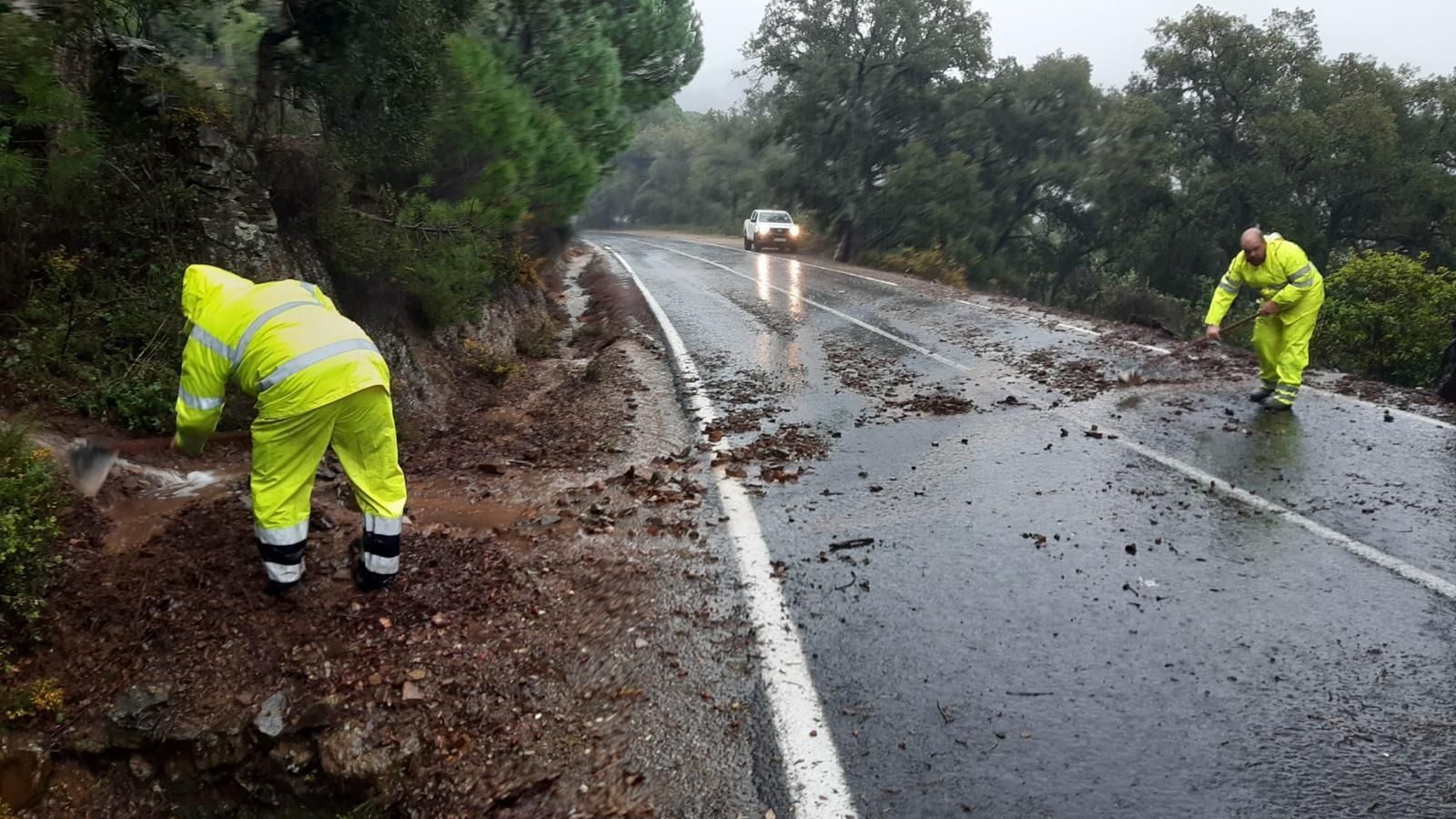 Operarios de la red de carreteras provincial despejando una de las carreteras afectadas por el temporal.
