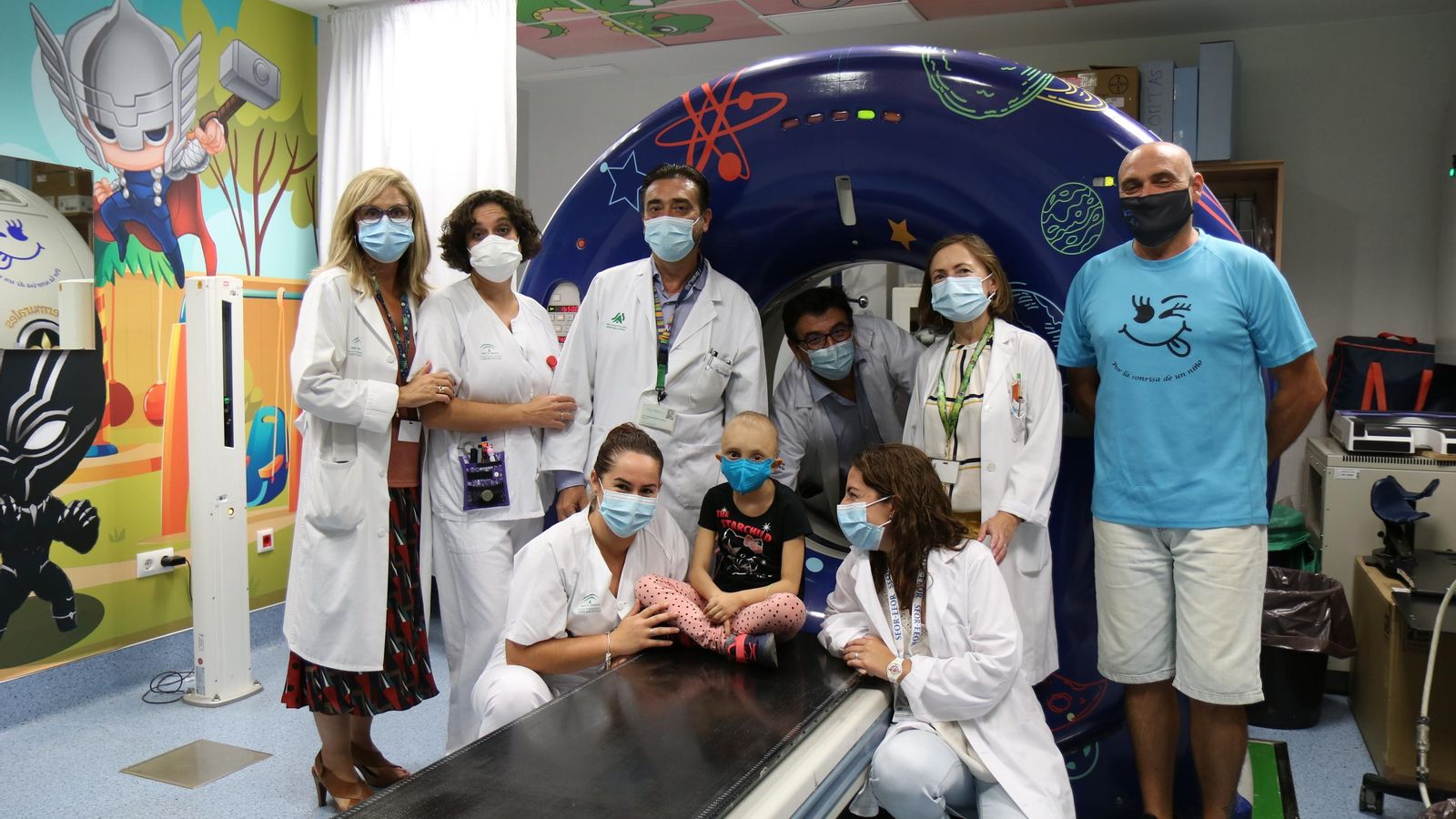 El el doctor David Muñoz Carmona (tercero por la izda.) junto a una menor y su familia y el equipo de profesionales del servicio de Oncología Radioterápica.