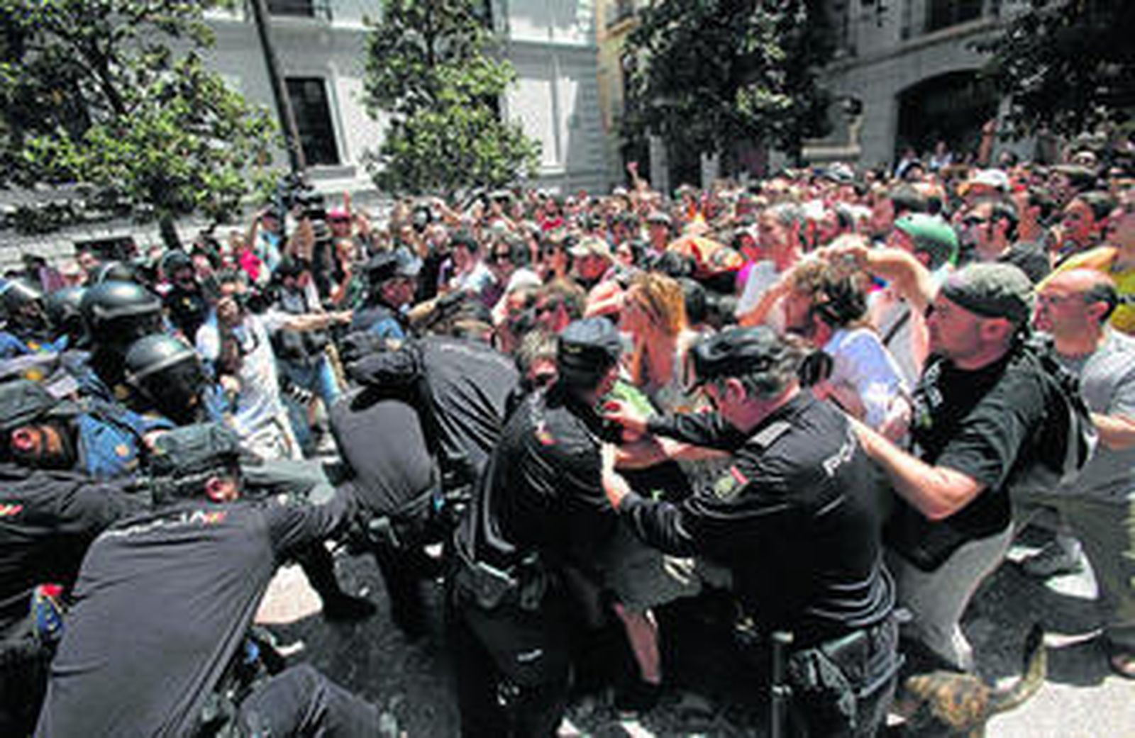 Un momento de tensión: los policías tratan de llevarse a un congregado que no se identificó y sus compañeros intentan impedirlo.