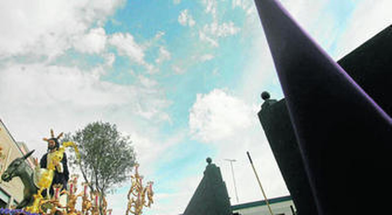 Silueta de Nuestro Padre Jesús del Amor recortada ante un cielo con nubes, pero claro.