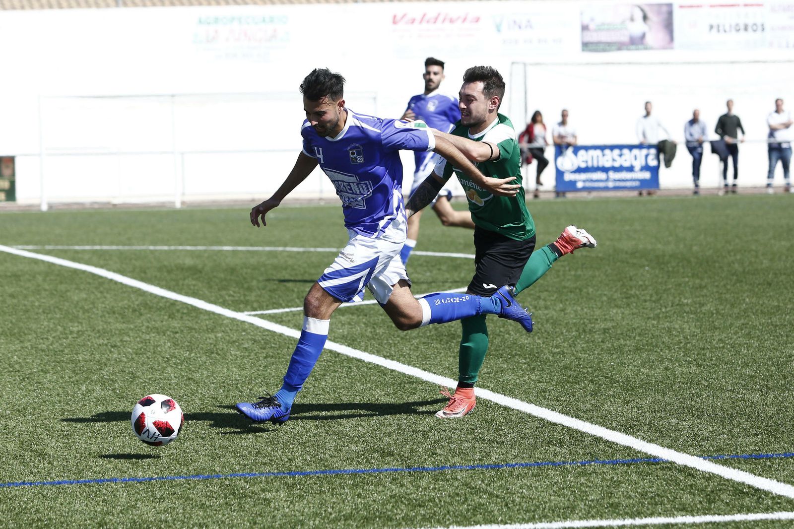 Un jugador del Huétor Vega persigue a un futbolista del Alhaurino.