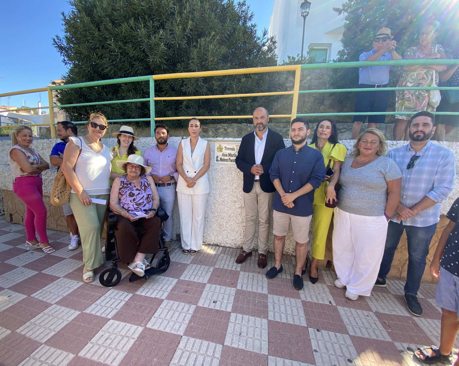 Los asistentes posan junto a la placa de la nueva calle Ana María Mateos