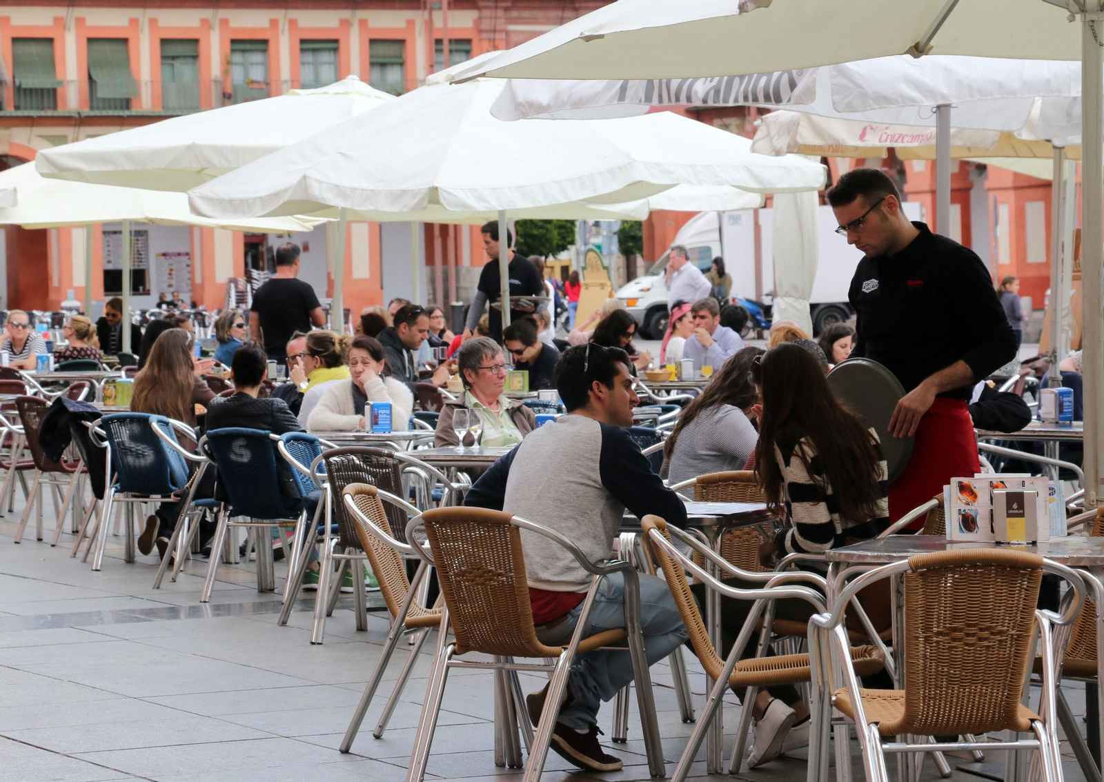 Un camarero atiende una mesa en una plaza de la Corredera