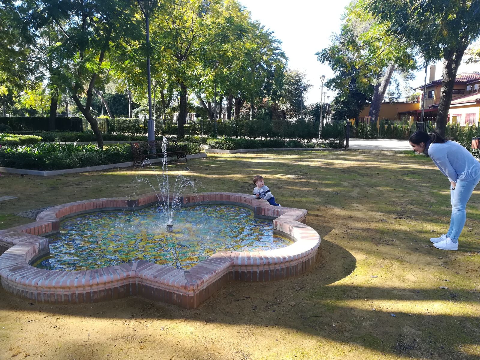 Una joven juega con un niño pequeño en una zona del parque Reina Victoria.