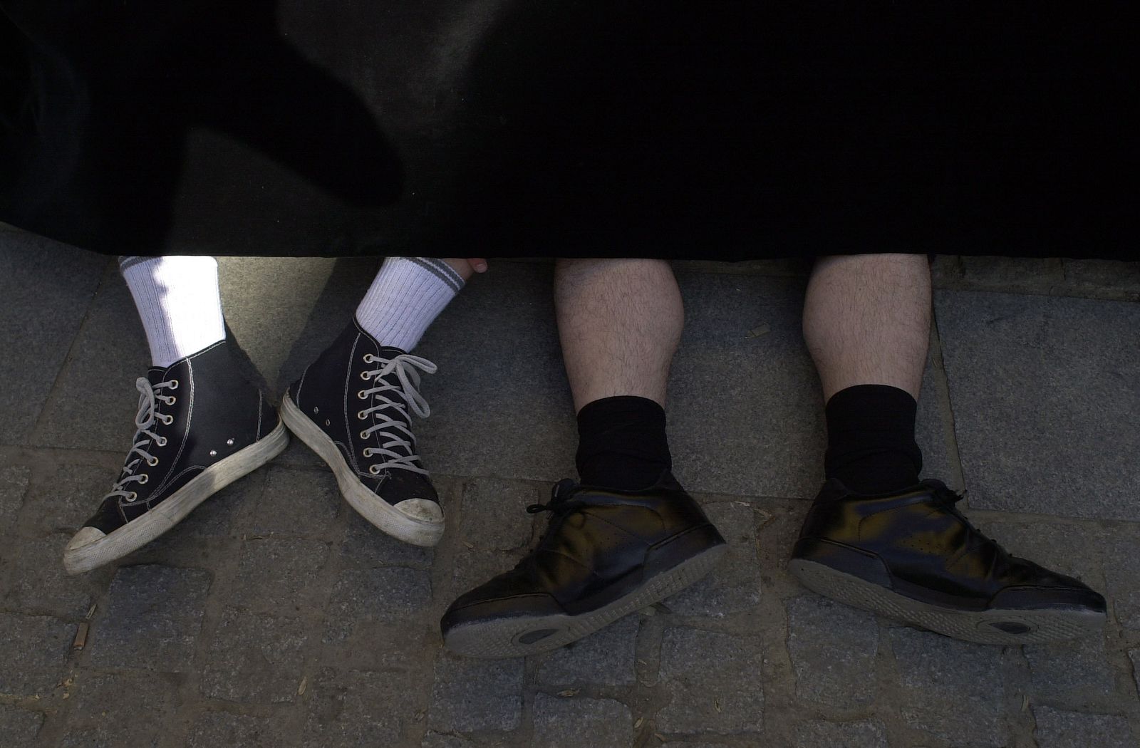 Los pies de los costaleros asoman bajo los faldones de un paso.