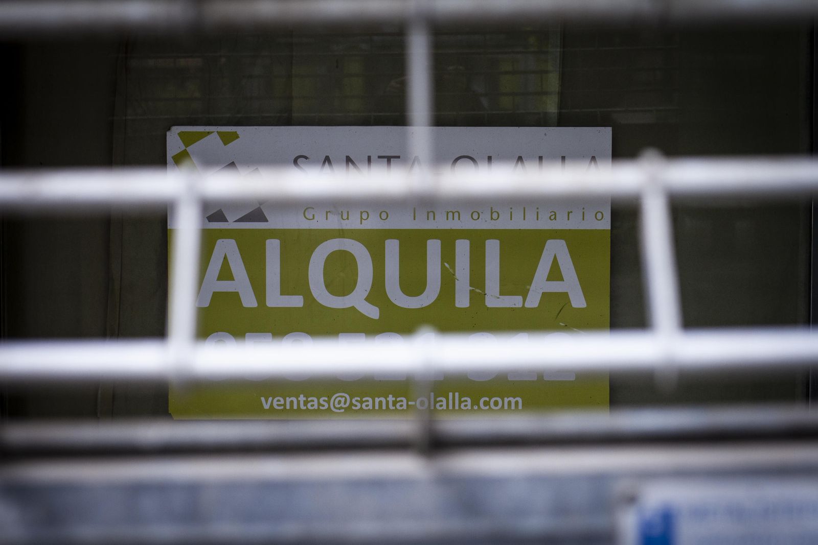 Cartel de inmobiliaria con un anuncio para alquilar un piso.