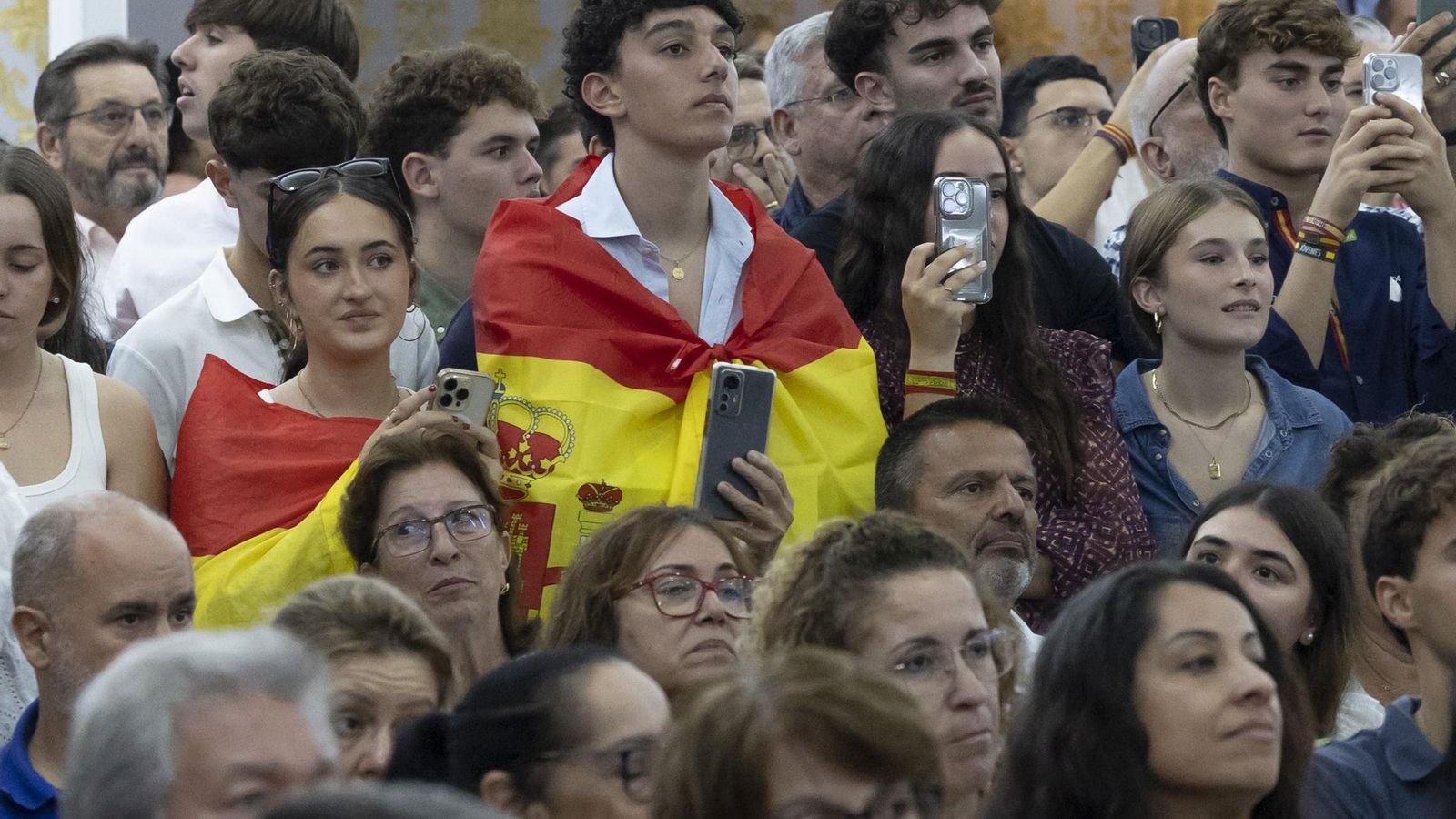 Unos jóvenes atienden un discurso de Abascal.