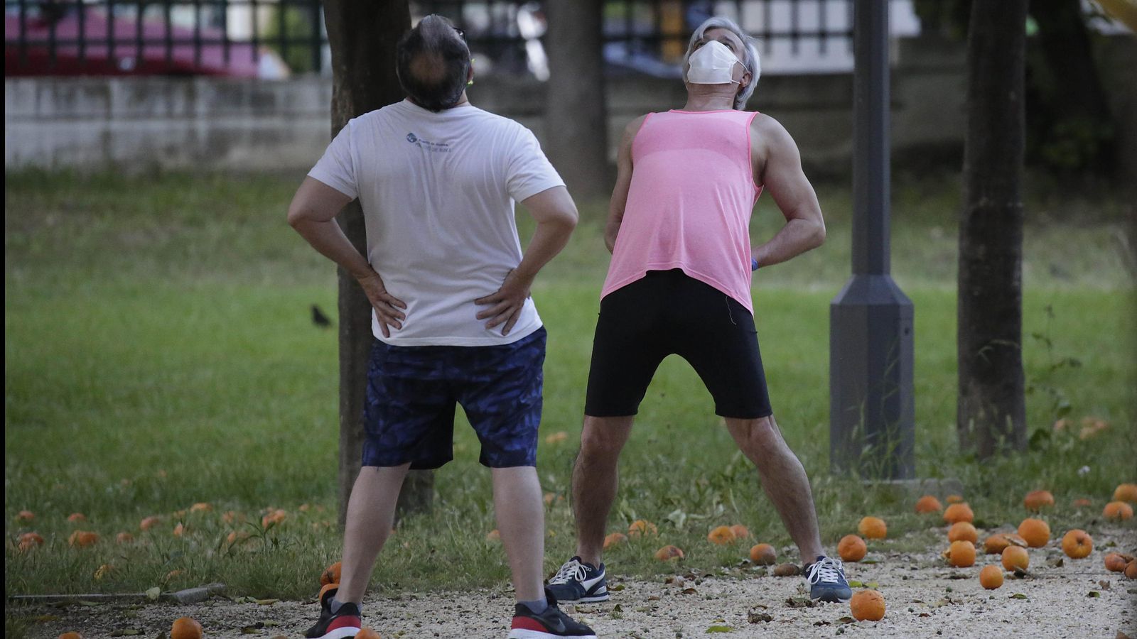 Dos personas haciendo estiramientos al aire libre.