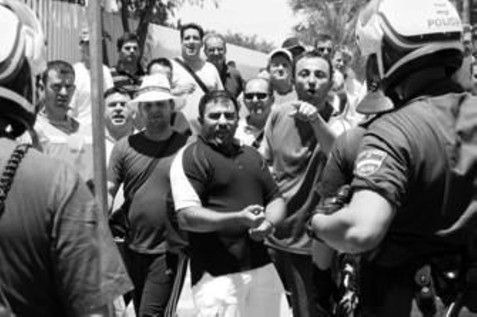 Uno de los siete detenidos en la Avenida de Torneo es conducido al furgón policial.